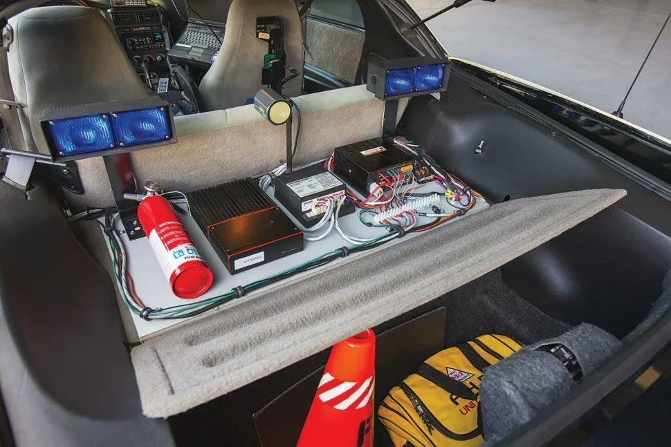 The black box on the left is for the 2-way radio. The box in the middle is the power supply for the strobe lights, and the box on the right is part of the Federal Signal Smart Siren that controls the siren and lights. The owner swapped in the proper shotgun rack on the back of the passenger’s seat, and the yellow first aid bag is original to this car.